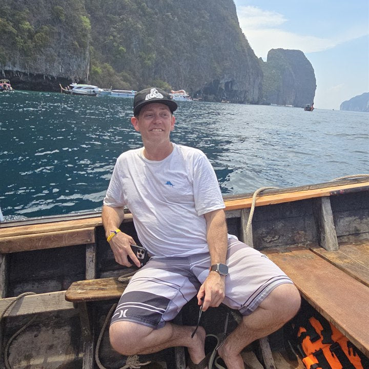 Customer wearing a black Nuwud logo hat while seated on a boat
